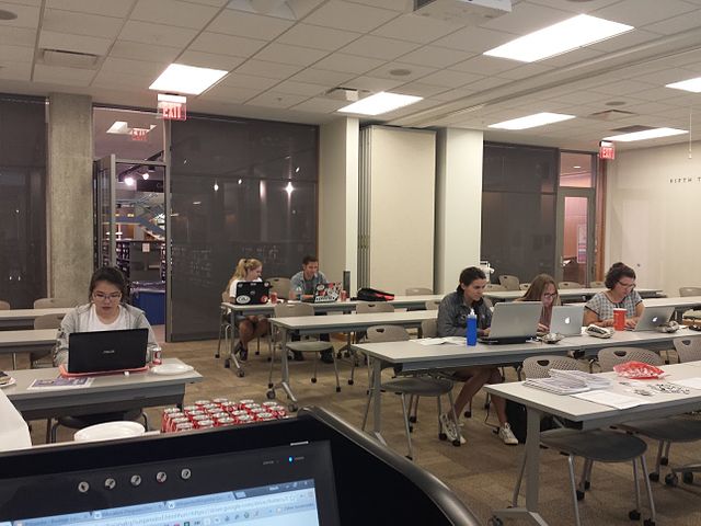 A library meeting room with several participants sitting with their laptops, editing Wikipedia articles.